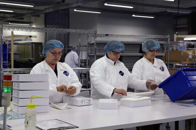 image of three people working on packaging process