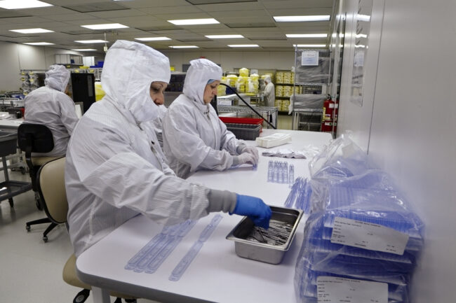 image of a two people putting medical devices into containers