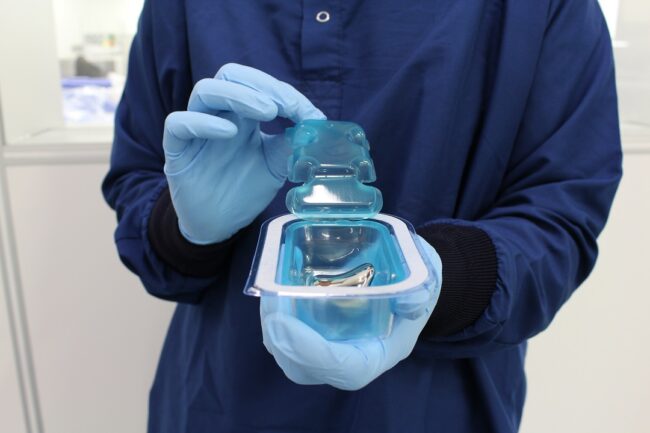 image of a person holding open a container with a medical device in it