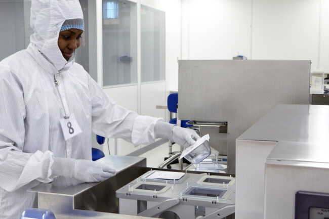 image of a person in a cleanroom holding a container